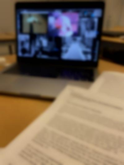 Open laptop computer, showing a desktop with several open image files. Two text printouts are laying next to the computer.